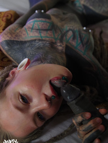 Heavily tattooed woman gives a blowjob while fondling pierced nipples