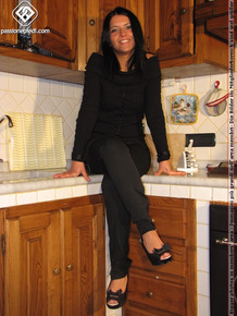 Dark haired female frees her pretty feet from high heeled shoes on counter