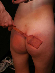 Redhead female is spanked after being covered in candle wax