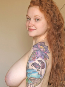 Tattooed redhead with huge floppy tits romping naked on the bed