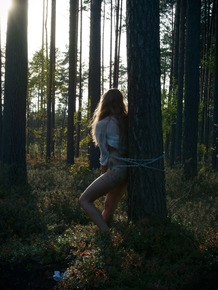 Handcuffed teen Kristine masturbates while being chained to a tree in woods