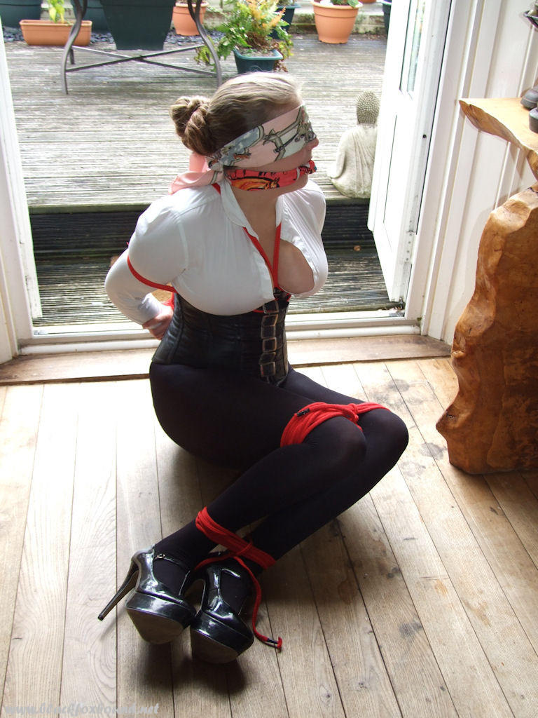 Blonde chick is left tied up, blindfolded and gagged inside front door photo