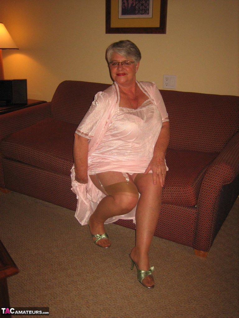Amateur granny on the heavy side shows her pussy in lingerie and tan nylons  image photo